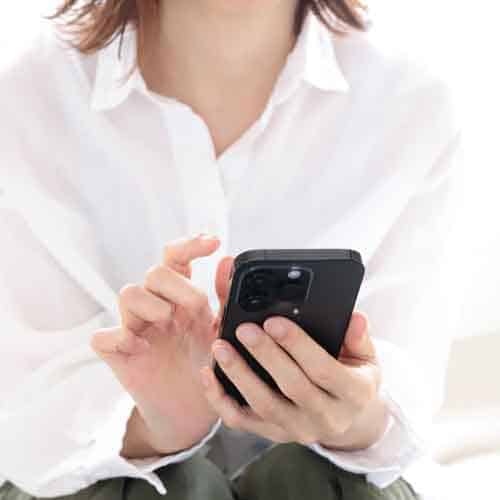 スマートフォンを持つ女性の手元写真